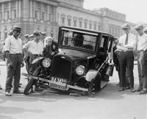 Vintage scene of crashed car with people standing around it